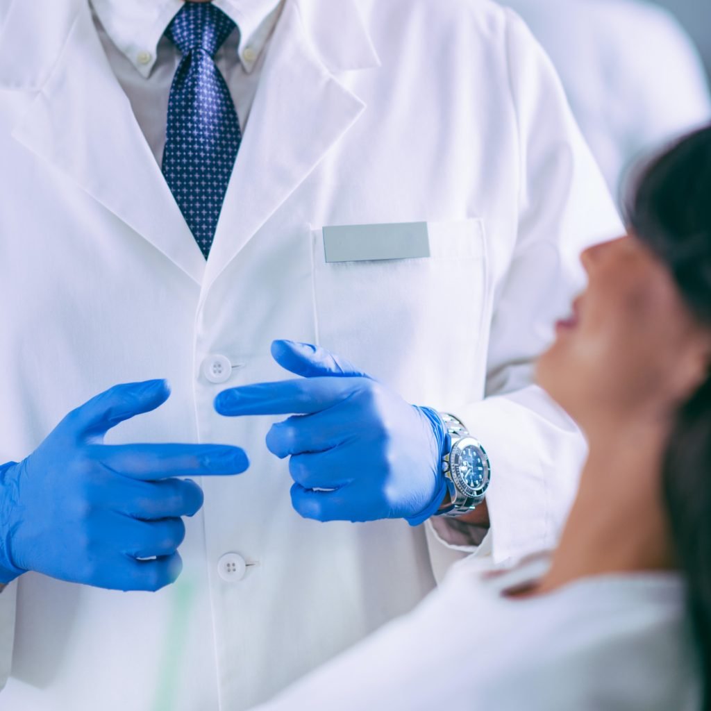 Young Dentist Talking to Satisfied Patient